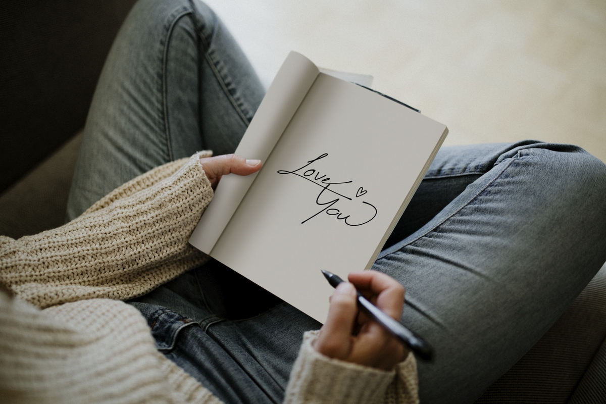 a person writing love you in their journal
