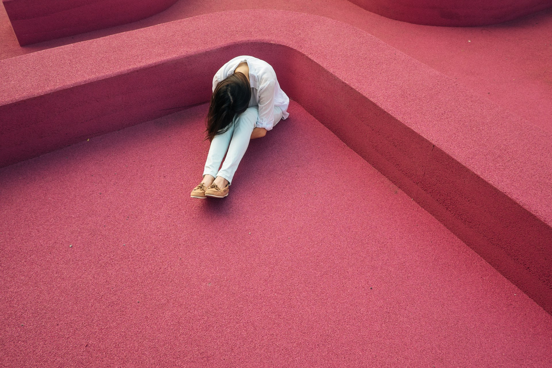 verne-ho-VIO0tyzXL4U-unsplash A woman with her head down trying to stop overthinking.